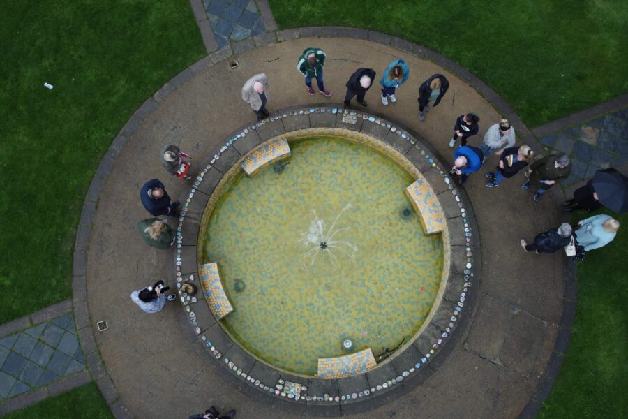 A group of people gather around a fountain.